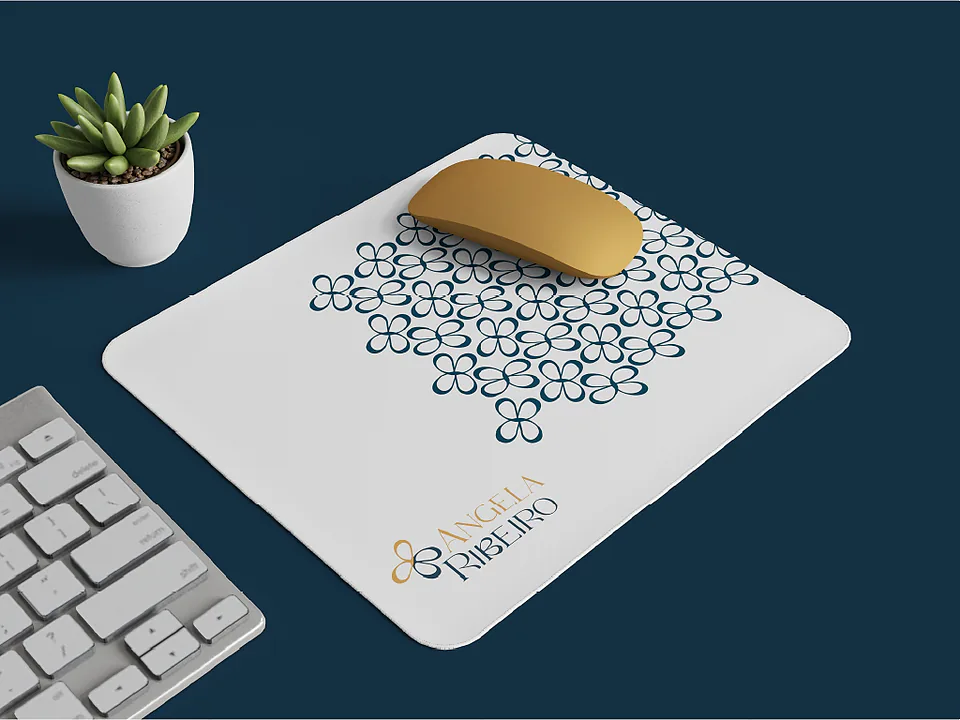 Mouse pad branco com padrão de pétalas ao lado de teclado e suculenta
