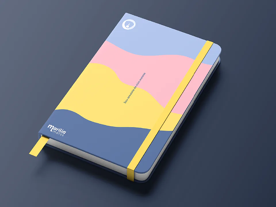 Caderno azul com ondas rosa e amarela na capa e a marca Marília Matos