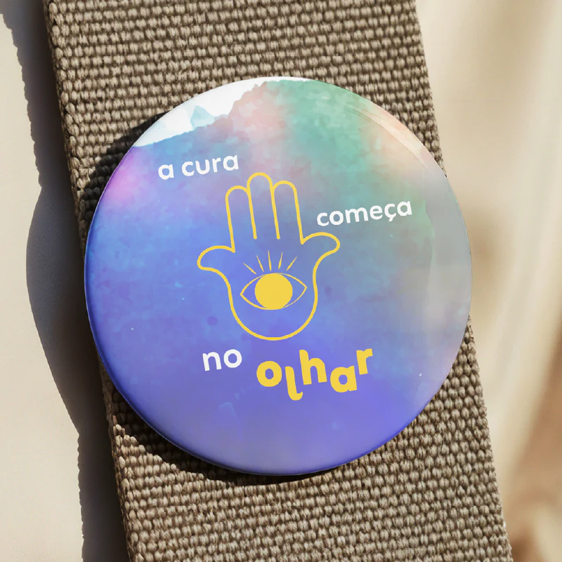 Bótom iridescente com a frase a cura começa no olhar