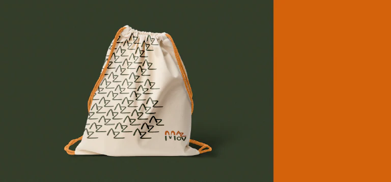 Mochila saco de algodão com padronagem da marca, entre fundo verde e laranja