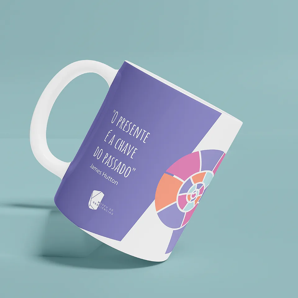 Caneca branca com faixa lilás, a frase "O presente é a chave do passado", de James Hutton, e uma amonite em rosa, laranja e lilás, sobre fundo verde-água