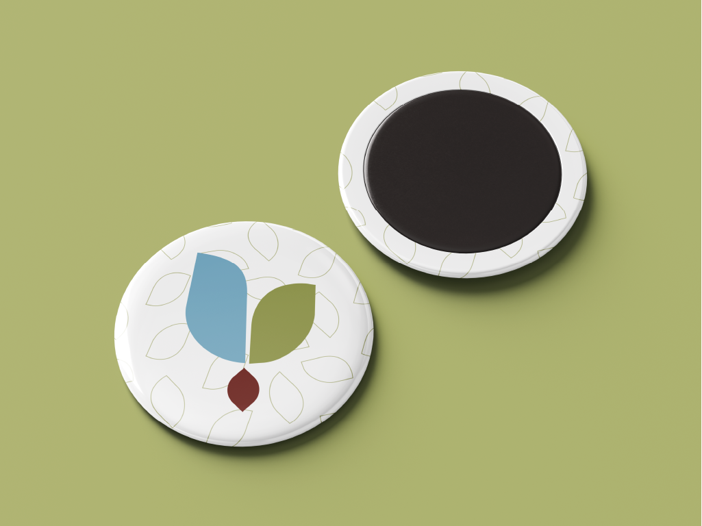 Ímãs redondos brancos com padrão de folhas e símbolo colorido da marca Dani Costa Psicóloga sobre fundo verde claro.